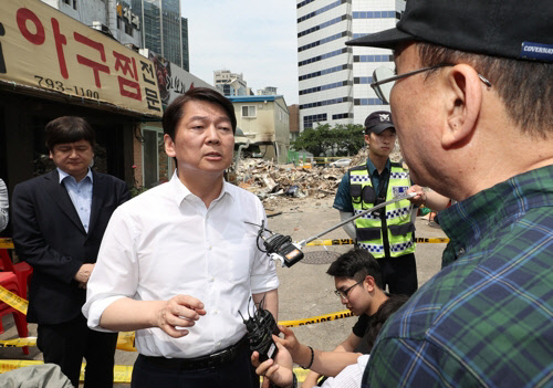 안철수 바른미래당 서울시장 후보가 4일 용산 건물붕괴 현장을 방문해 붕괴 건물에 입주해 있던 식당 주인과 이야기를 하고 있다. 연합뉴스